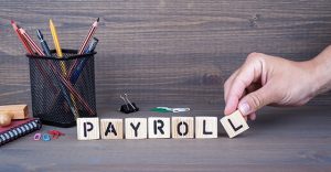 payroll. Wooden letters on dark background