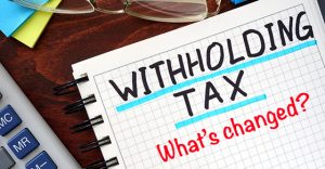 Whithholding tax WHT concept written in a notebook on a wooden table.